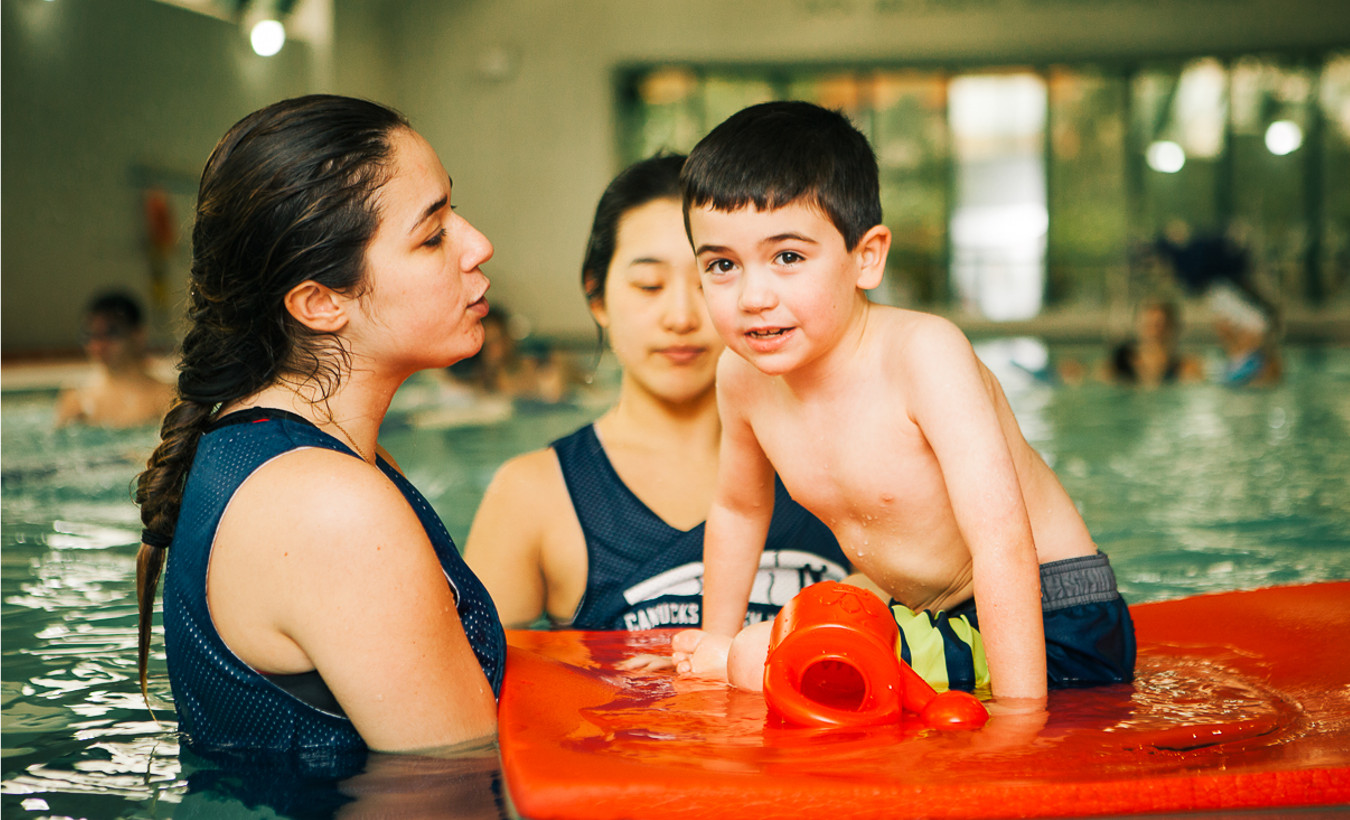 A young boy is floating on a raft in a pool.