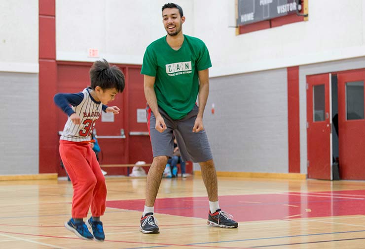 A volunteer and a child with autism jump together in our I CAN Be Active program.