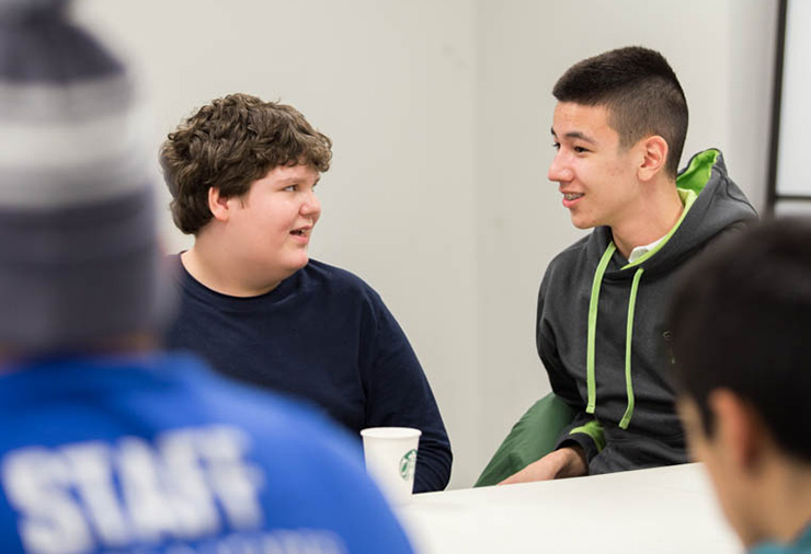 Two teens with autism talk with one another in our Weekly Social Program.